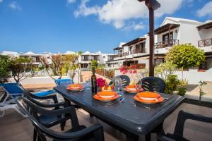 una mesa negra con sillas y comida en el patio en Casa Del Mar, en Playa Blanca