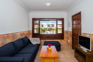 sala de estar con sofá azul y mesa en Casa Del Mar, en Playa Blanca