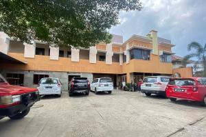 a group of cars parked in front of a building at RedDoorz Syariah @ Jalan Ir Haji Juanda Jambi in Jambi