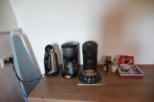 a coffee maker on a wooden table next to a wall at The Wine Cellar in the Old Gemeinde House in Brauneberg