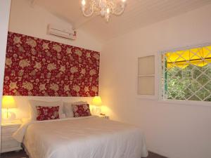 a bedroom with a white bed and a window at Hotel Vivenda Penedo in Penedo