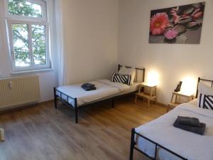 a room with two beds and a window at Apartment Ferienwohnung Martin Luther, 3 Schlafzimmer, free WiFi, Nähe Zentrum, klimatisiert, hell, offen, sehr schön, in Jena