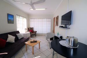 a living room with a couch and a table at Garden Cottage in Edenvale in Edenvale