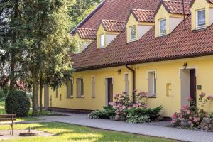 żółty dom z czerwonym dachem w obiekcie Ośrodek Szkoleniowo - Noclegowy Chojnik w mieście Sośnie