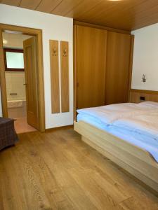 a bedroom with a large bed and a bathroom at Residence Cesa Callegari in Selva di Val Gardena