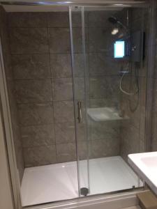 a shower with a glass door in a bathroom at The Wheel House in Mevagissey