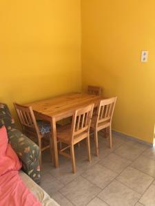 comedor con mesa de madera y sillas en Bem apartman, en Jászárokszállás