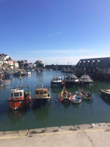 a group of boats are docked in a harbor at The Wheel House in Mevagissey
