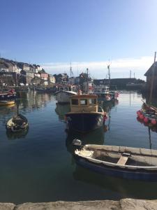 een groep boten is aangemeerd in een haven bij The Wheel House in Mevagissey