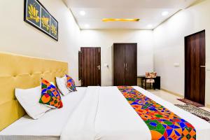 a bedroom with a large bed with colorful pillows at FabHotel The Castle Homestay in Jaipur