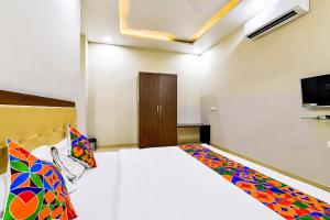 1 dormitorio con 1 cama y TV en la pared en FabHotel The Castle Homestay en Jaipur