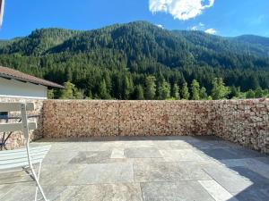a bench on a patio with a stone wall at Alpine Apartment Belluca in Gries im Sellrain