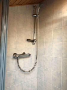 a shower with a hose on a tiled wall at Apartment Eden in Glödnitz