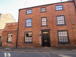 a red brick building with a black door and windows at 12 Banks Street in Horncastle