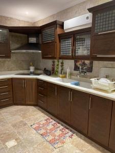 a kitchen with wooden cabinets and a sink at شاليه اوتار Strings Chalet in Riyadh