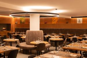 un restaurant avec des tables et des chaises et un grand lustre dans l'établissement Hotel Zerbion, à Torgnon