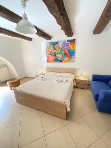 ein Schlafzimmer mit einem Bett und einem blauen Sofa in der Unterkunft ChSuite & PrivateParking - Corso 18 Agosto - Apartment in Potenza