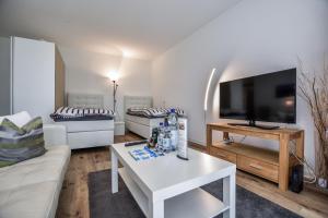 a living room with a white couch and a tv at Domicile Cologne in Cologne