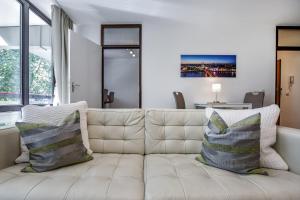 una sala de estar con un sofá blanco con almohadas en Domicile Cologne, en Colonia