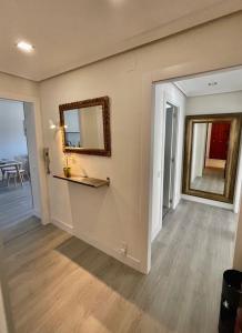 a living room with a mirror and a table at Apartamento Buenavista in Oviedo