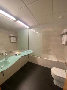 a bathroom with a sink, toilet and shower at Hospedium Hotel Villa Gomá in Zaragoza