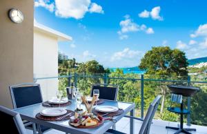 a table and chairs on a balcony with a view at Tulip Oak in Airlie Beach