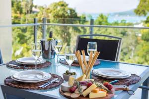 a table with plates of food and glasses of wine at Tulip Oak in Airlie Beach