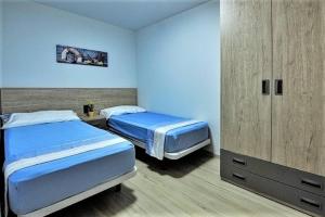 1 Schlafzimmer mit 2 Betten und einem Schrank in der Unterkunft APTMUNDO BAJAMAR - Precioso apartamento Planta baja y patio in Puerto de Sagunto