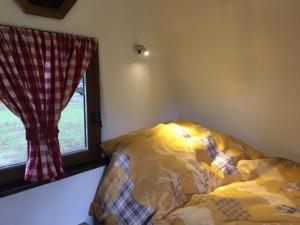een slaapkamer met een bed en een raam bij Beautiful unique Barrel in lakeview tranquility in Perrou