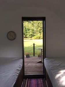 een kamer met 2 bedden en een deur naar een patio bij Beautiful unique Barrel in lakeview tranquility in Perrou