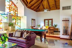 a living room with a pool table and stained glass windows at Luxury Villa Casa De Campo in La Romana