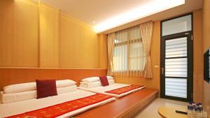 Un pat sau paturi într-o cameră la Qian's Garden Inn