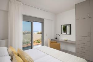 een slaapkamer met een bed en een groot raam bij Kallithea Residence in Rethimnon