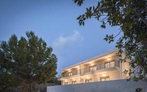 a white building with trees in front of it at Kallithea Residence in Rethymno