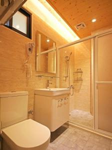 W łazience znajduje się toaleta, umywalka i prysznic. w obiekcie Qian's Garden Inn w Lugu