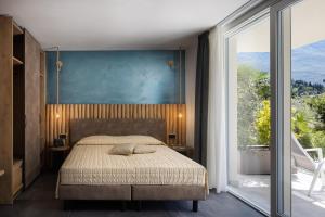 a bedroom with a bed and a large window at Aris Apartments & Sky Pool - TonelliHotels in Riva del Garda