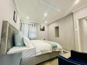 a bedroom with a bed and a table and chairs at Cozier Glitz in Cape Town