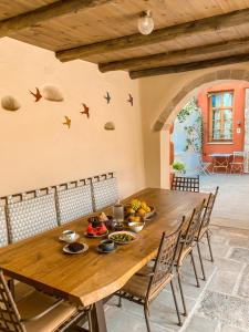 uma sala de jantar com uma mesa de madeira e cadeiras em Veranda Rossa Suites em Retimno