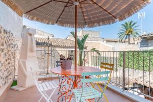 d'une table et de chaises sur un balcon avec un parasol dans l'établissement Cas Solleric, à Petra