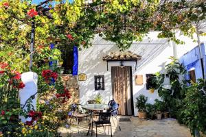 a patio in front of a white house with flowers at La Posada Amena in Carcabuey
