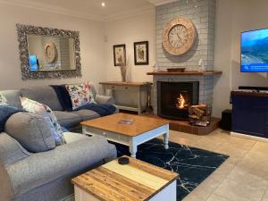 a living room with a couch and a fireplace at 2 Rawdons Country Estate in Nottingham Road