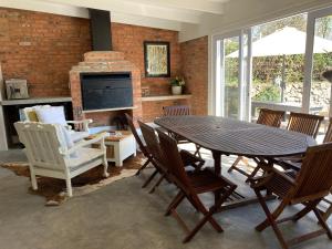 een eetkamer met een tafel en stoelen en een open haard bij 2 Rawdons Country Estate in Nottingham Road