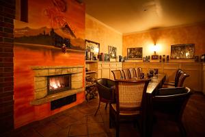 a restaurant with a fireplace and a table and chairs at Pension Rüssel-Pub in Sangerhausen