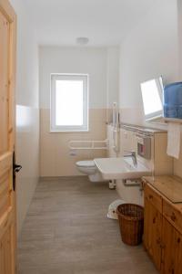 La salle de bains est pourvue de 2 lavabos et d'une fenêtre. dans l'établissement Pension Biohof Klügel, à Freital