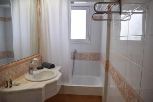 
a white bath tub sitting under a window in a bathroom at Savoy Hotel in Piraeus

