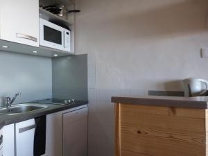 a small kitchen with a sink and a microwave at travelski home select - Vue Mont Blanc in Aime-La Plagne