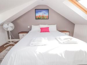 1 dormitorio con cama blanca y almohada rosa en Upper 3, en Dartmouth