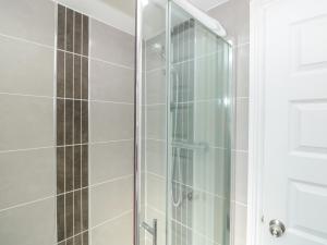 una ducha con puerta de cristal en un baño en Upper 3, en Dartmouth 14 fotos más