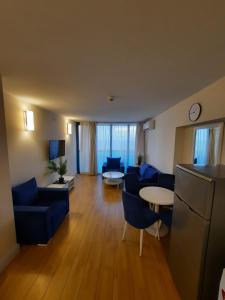 ein großes Wohnzimmer mit blauen Stühlen und einem Tisch in der Unterkunft Twins tower orbi city in Batumi