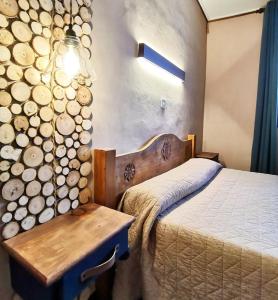 ein Schlafzimmer mit einem Bett neben einem Holzstapel in der Unterkunft La Vieille Auberge in Vars